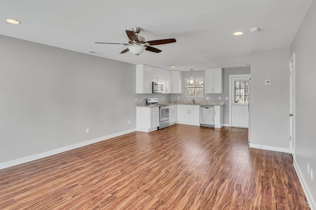 unfurnished living room with dark hardwood / wood-style flooring, sink, and ceiling fan