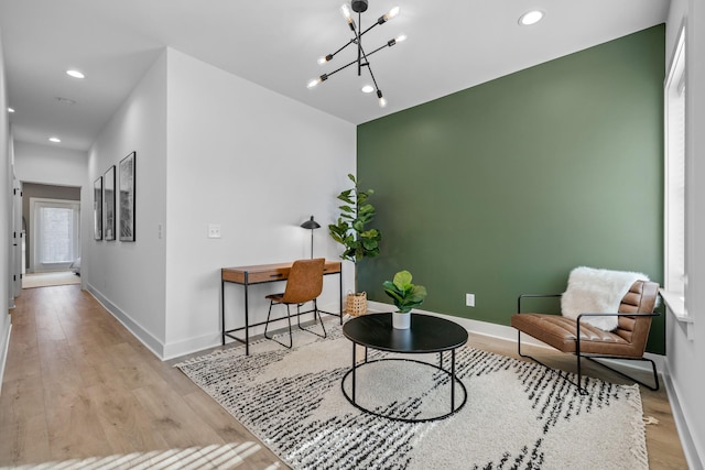 sitting room featuring an inviting chandelier and light hardwood / wood-style flooring