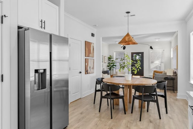 dining area featuring light hardwood / wood-style flooring and ornamental molding