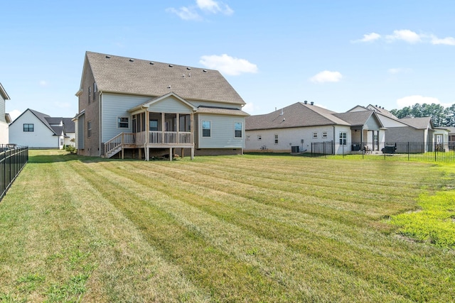 back of house with a sunroom, a yard, and central air condition unit