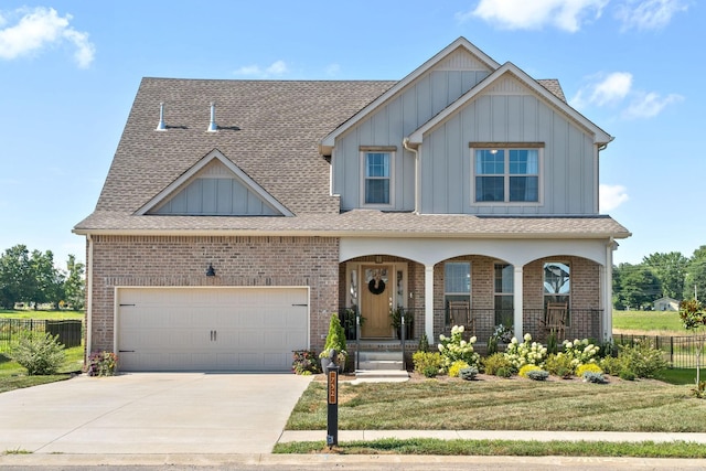 view of front of home featuring a garage, covered porch, and a front yard