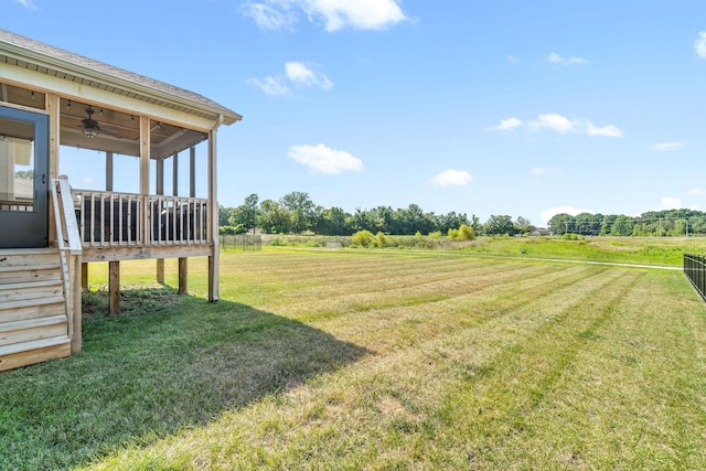 view of yard featuring ceiling fan and a rural view