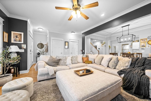 living room featuring light hardwood / wood-style flooring, ornamental molding, and ceiling fan