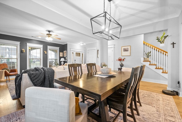 dining room with crown molding, light hardwood / wood-style flooring, and ceiling fan with notable chandelier