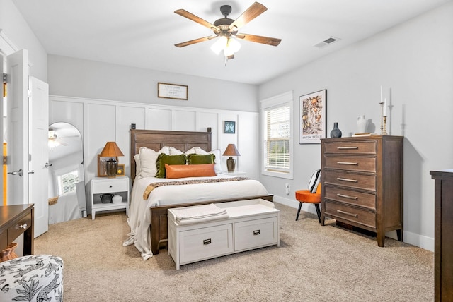 bedroom featuring multiple windows, light colored carpet, and ceiling fan