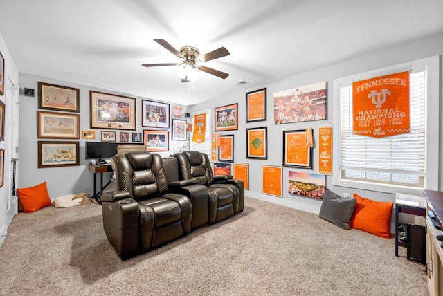 carpeted cinema room with ceiling fan