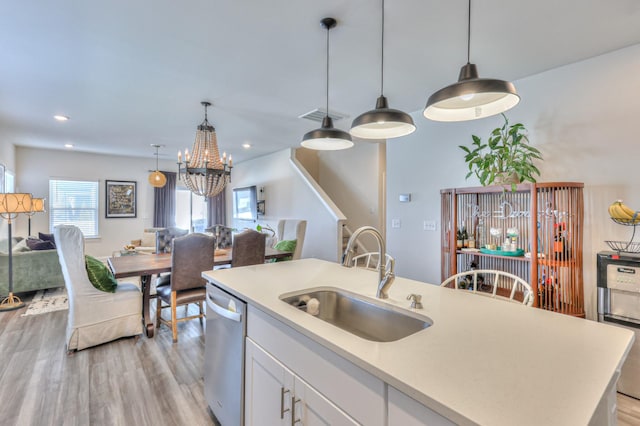 kitchen with white cabinetry, dishwasher, sink, and hanging light fixtures