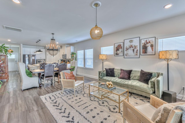 living room featuring hardwood / wood-style floors and a notable chandelier