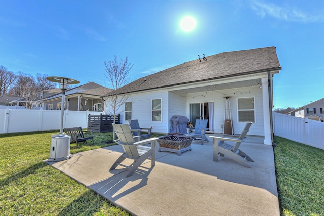 rear view of house with a patio, a fire pit, and a lawn