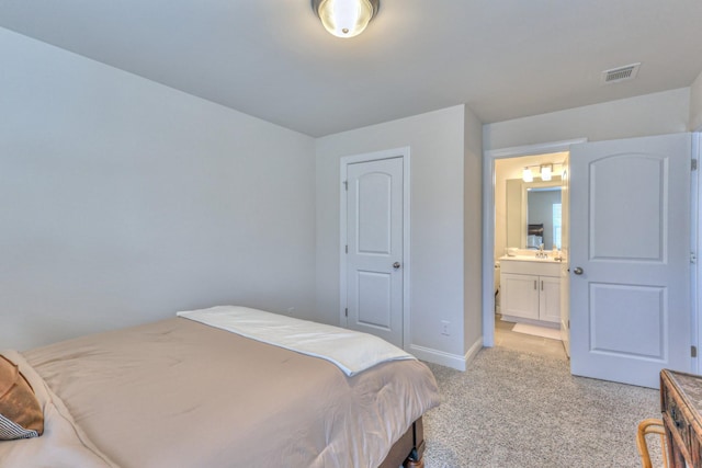 carpeted bedroom featuring ensuite bathroom