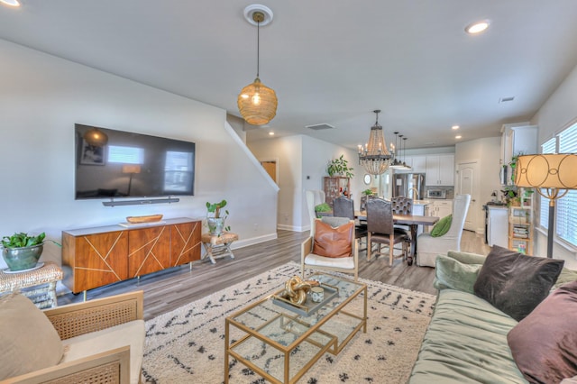 living room featuring a chandelier and light hardwood / wood-style flooring