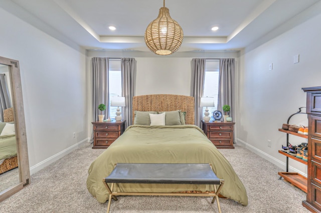 carpeted bedroom featuring a raised ceiling