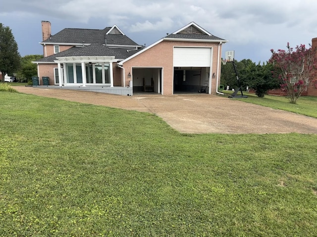 back of property with a garage and a lawn