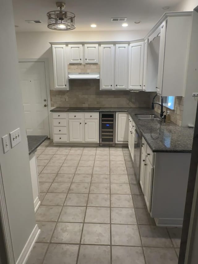 kitchen with white cabinetry, sink, dark stone countertops, and wine cooler