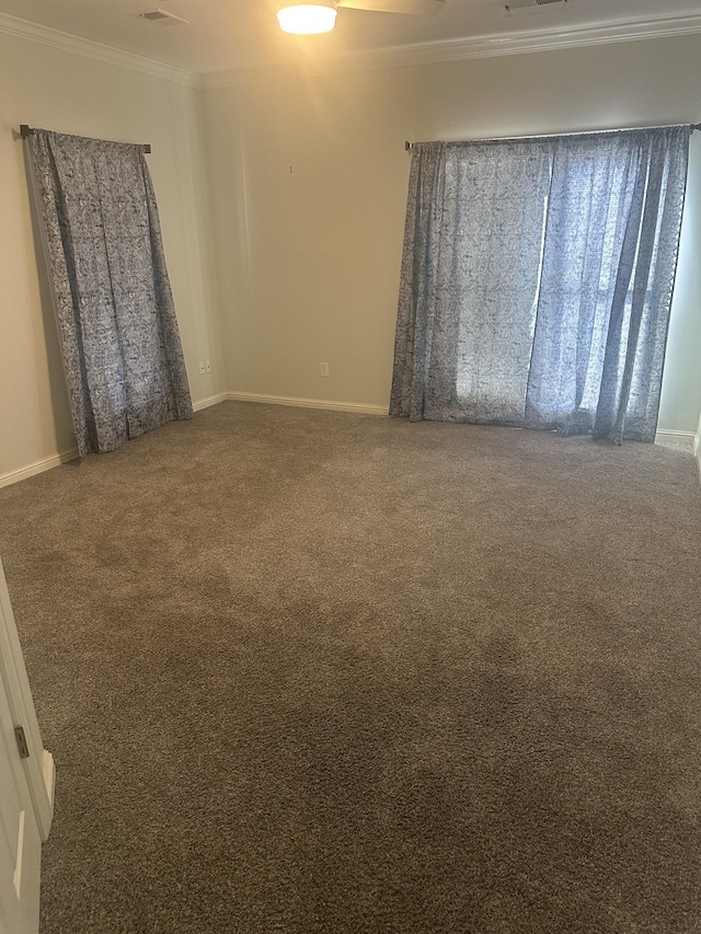 spare room with dark colored carpet and crown molding