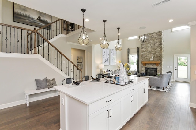 kitchen featuring pendant lighting, dark hardwood / wood-style floors, a center island, and white cabinets