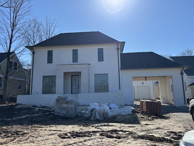 rear view of property featuring central AC unit and a garage