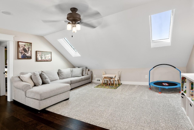 living room featuring dark wood-type flooring, ceiling fan, and vaulted ceiling with skylight