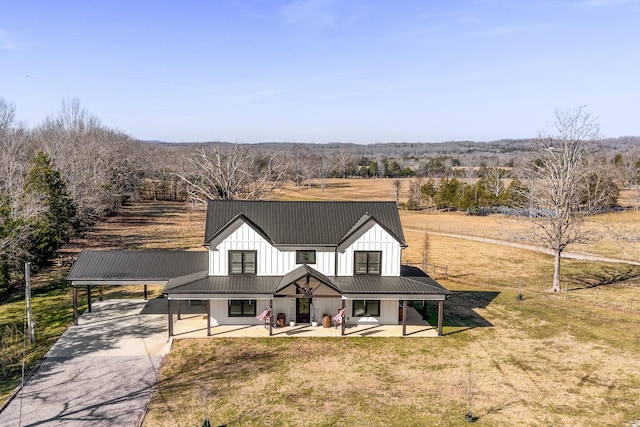 modern farmhouse with a porch, a front yard, and a rural view