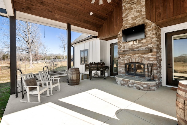 view of patio / terrace with ceiling fan and an outdoor stone fireplace