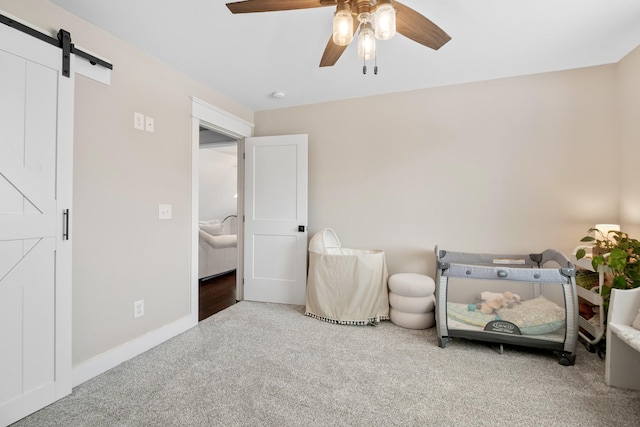 bedroom with a barn door, carpet flooring, and ceiling fan