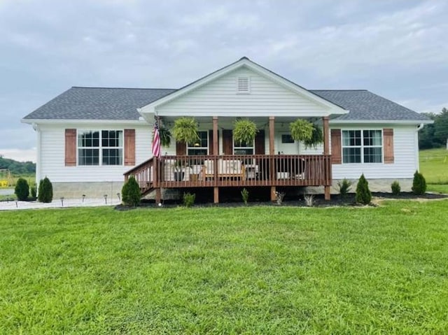 rear view of property featuring a deck and a lawn