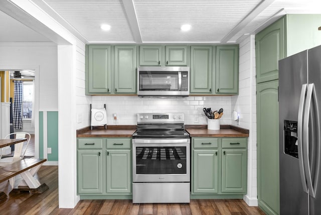 kitchen with appliances with stainless steel finishes, dark hardwood / wood-style floors, wood counters, and green cabinetry