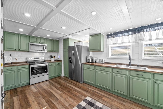 kitchen with stainless steel appliances, sink, green cabinets, and dark hardwood / wood-style floors