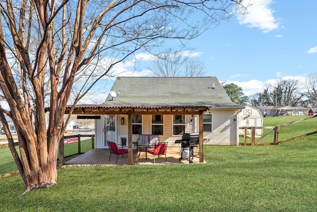 back of property featuring a yard, a shed, and a patio area