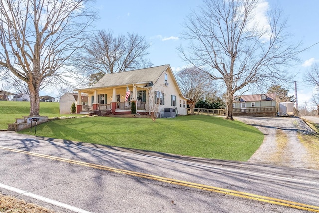 view of front of property with central air condition unit, covered porch, and a front lawn