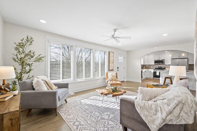 living room with ceiling fan and light hardwood / wood-style flooring