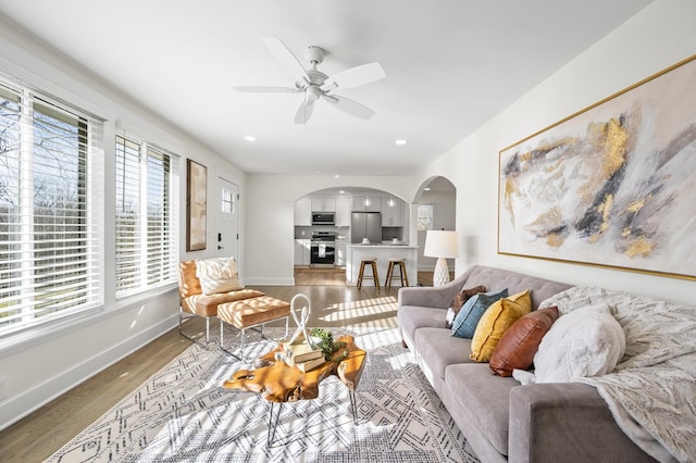 living room featuring dark wood-type flooring and ceiling fan