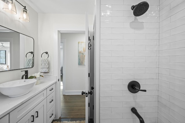 bathroom with vanity, wood-type flooring, and a tile shower