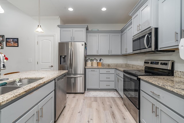 kitchen featuring sink, gray cabinets, stainless steel appliances, light stone counters, and light wood-type flooring