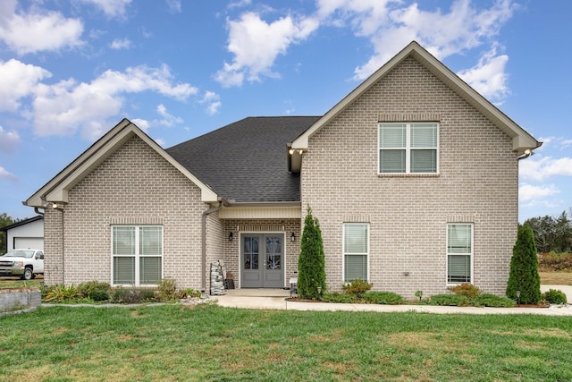 front facade featuring french doors, a patio area, and a front lawn