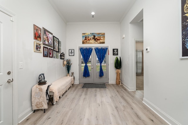 foyer with crown molding and light hardwood / wood-style floors