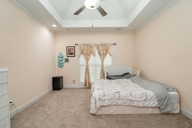 carpeted bedroom with a raised ceiling, crown molding, and ceiling fan