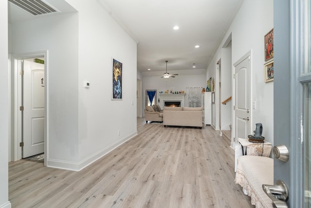 corridor featuring crown molding and light hardwood / wood-style flooring