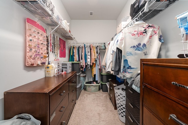 walk in closet featuring light carpet