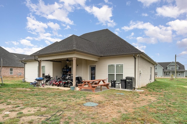 rear view of house with a patio, ceiling fan, and a lawn