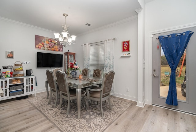 dining area featuring crown molding, a notable chandelier, and light wood-type flooring