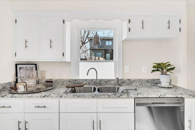 kitchen with white cabinetry, sink, stainless steel dishwasher, and light stone counters