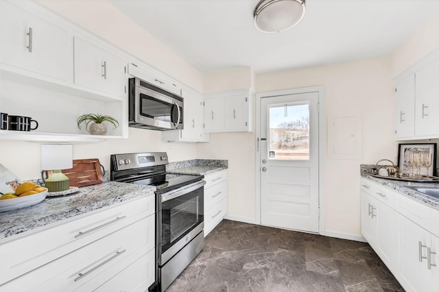 kitchen with light stone countertops, white cabinetry, and appliances with stainless steel finishes