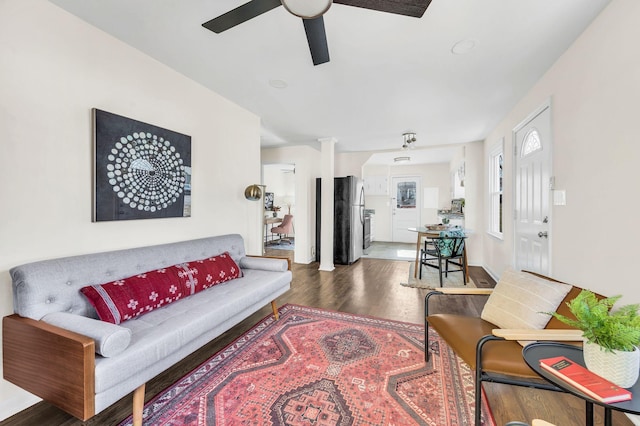 living room featuring ceiling fan and dark hardwood / wood-style flooring