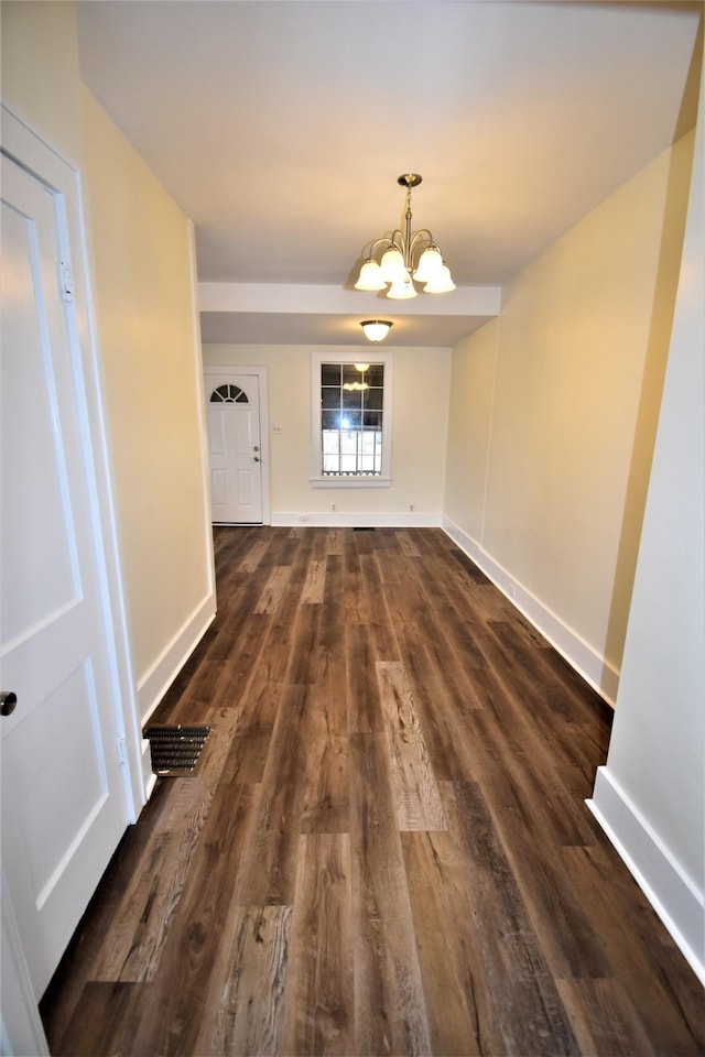 unfurnished dining area featuring a notable chandelier and dark wood-type flooring