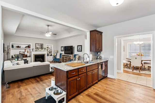 kitchen with a raised ceiling, sink, dishwasher, and light hardwood / wood-style flooring