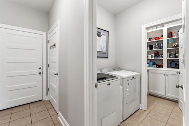 laundry room with washing machine and dryer and light tile patterned floors