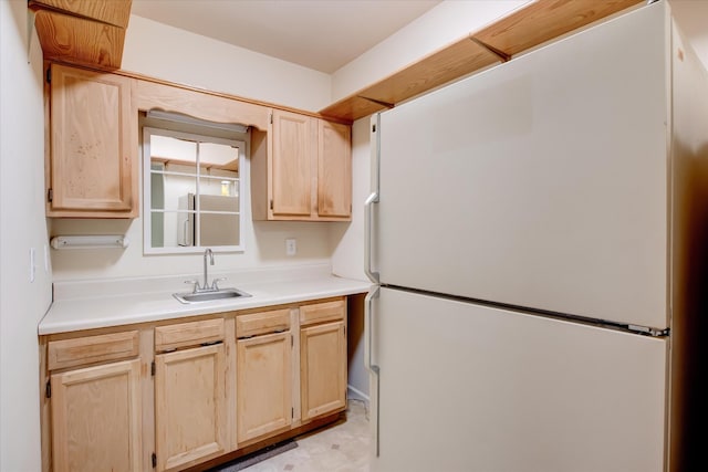 kitchen featuring sink, white fridge, and light brown cabinets