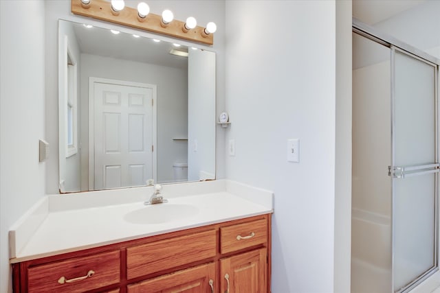 bathroom featuring walk in shower, vanity, and toilet