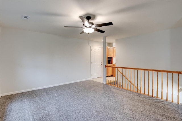 spare room with ceiling fan and light colored carpet